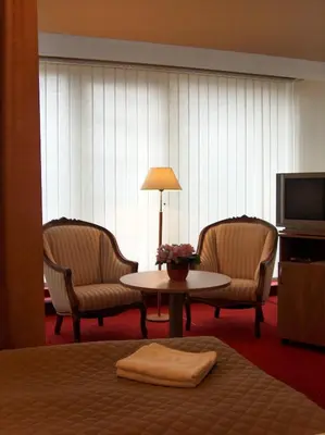a hotel room with two chairs and a table and a television at City Gate in Vilnius
