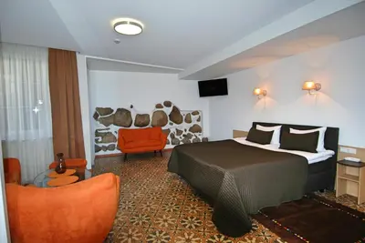 a hotel room with a bed and a chair at City Gate in Vilnius