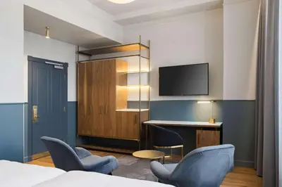 a hotel room with a bed and a desk and a tv at Radisson Collection Astorija Hotel, Vilnius in Vilnius