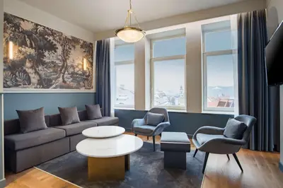 a living room with a couch and chairs and a table at Radisson Collection Astorija Hotel, Vilnius in Vilnius