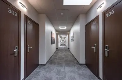 a corridor of a hallway with doors in a building at Vilnius City Hotel in Vilnius