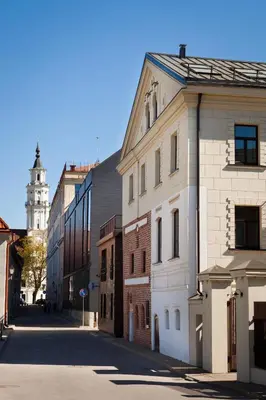 an empty city street with buildings and a clock tower at Daugirdas Old City Hotel in Kaunas
