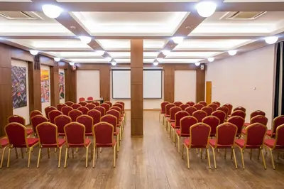 an empty room with rows of chairs in a classroom at Daugirdas Old City Hotel in Kaunas
