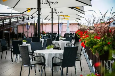 a restaurant with tables and chairs and flowers at Daugirdas Old City Hotel in Kaunas