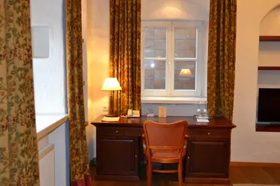 a desk in a room with a window and a chair at Daugirdas Old City Hotel in Kaunas