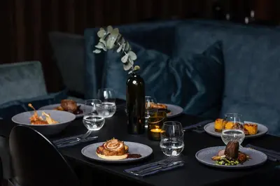 a table with plates of food and wine glasses at Daugirdas Old City Hotel in Kaunas