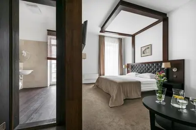 a bedroom with a bed and a large mirror at Amberton Cozy Hotel Kaunas in Kaunas