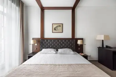a bedroom with a large bed and two lamps at Amberton Cozy Hotel Kaunas in Kaunas