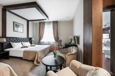 a hotel room with a bed and a table at Amberton Cozy Hotel Kaunas in Kaunas