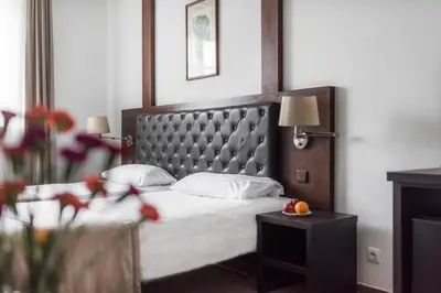 a bedroom with a bed and a table with fruit on it at Amberton Cozy Hotel Kaunas in Kaunas