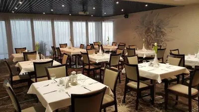 a dining room with white tables and chairs at Hotel Babilonas in Kaunas