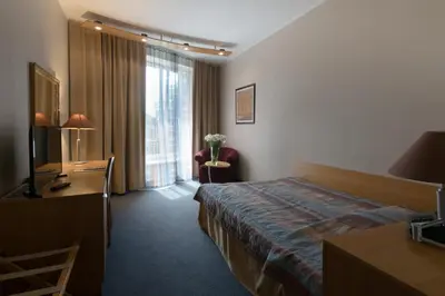 a hotel room with a bed and a desk at Perkuno Namai Park Hotel in Kaunas