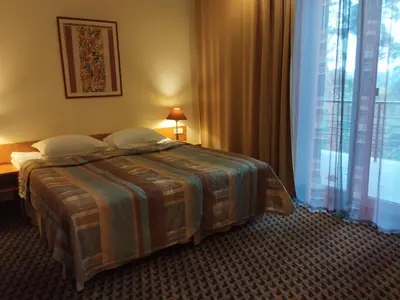 a hotel room with a bed and a large window at Perkuno Namai Park Hotel in Kaunas