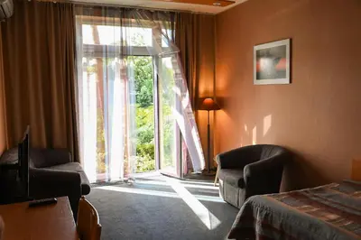 a hotel room with a bed and a large window at Perkuno Namai Park Hotel in Kaunas