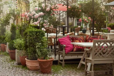 a patio with tables and chairs and potted plants at Stikliai Hotel - Relais & Châteaux in Vilnius