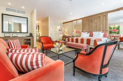 a hotel room with two beds and orange chairs at Stikliai Hotel - Relais & Châteaux in Vilnius