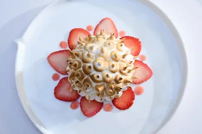 a white plate with a cake with strawberries on it at Stikliai Hotel - Relais & Châteaux in Vilnius