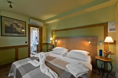 a bedroom with a bed with towels on it at BEST BALTIC Hotel Druskininkai Central in Druskininkai
