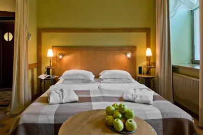 a bedroom with a bed with a bowl of fruit on a table at BEST BALTIC Hotel Druskininkai Central in Druskininkai