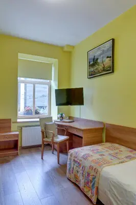 a bedroom with a bed and a desk and a window at In Astra in Vilnius