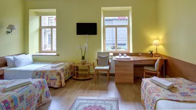 a hotel room with two beds and a desk at In Astra in Vilnius