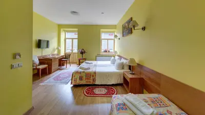 a hotel room with two beds and a desk and a room at In Astra in Vilnius