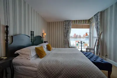 a bedroom with a large bed and a window at Apvalaus Stalo Klubas Gastro & SPA Hotel in Trakai