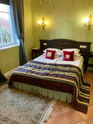 a bedroom with a large bed with red pillows at Apvalaus Stalo Klubas Gastro & SPA Hotel in Trakai