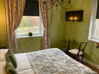a bedroom with a bed and a window at Apvalaus Stalo Klubas Gastro & SPA Hotel in Trakai