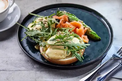 a plate of food with a sandwich and vegetables at Apvalaus Stalo Klubas Gastro & SPA Hotel in Trakai