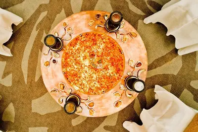 a pizza on a wooden plate on a table at SPA VILNIUS Druskininkai in Druskininkai