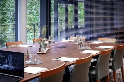 a large wooden table with chairs and a laptop on it at SPA VILNIUS Druskininkai in Druskininkai