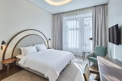 a hotel room with a bed and a chair at Neringa Hotel in Vilnius