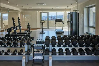 a gym with rows of chairs and tread machines at Neringa Hotel in Vilnius