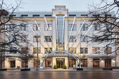 a white building with a clock tower on top of it at Neringa Hotel in Vilnius