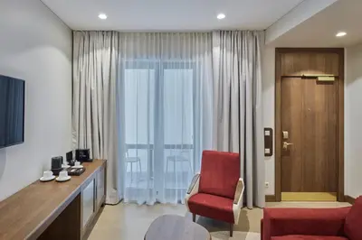 a living room with a red chair and a window at Neringa Hotel in Vilnius