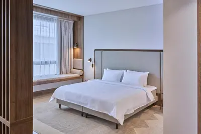 a bedroom with a large bed and a window at Neringa Hotel in Vilnius