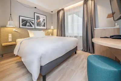 a hotel room with a large bed and a desk at Radisson Hotel Kaunas in Kaunas