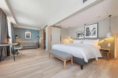 a hotel room with a large bed and a desk at Radisson Hotel Kaunas in Kaunas