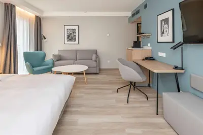 a hotel room with a bed and a couch and a table at Radisson Hotel Kaunas in Kaunas