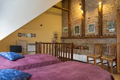 a bedroom with two beds and a brick wall at Bernardinu B&B House in Vilnius