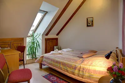 a bedroom with a bed and a desk and a window at Bernardinu B&B House in Vilnius