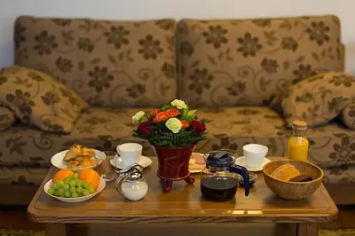 a coffee table with a vase of flowers and fruit at Bernardinu B&B House in Vilnius