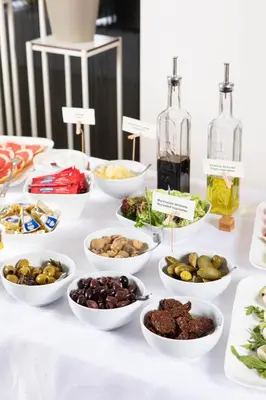 a table with bowls of food and bottles of alcohol at City Hotels Algirdas in Vilnius