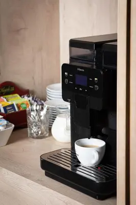a coffee maker sitting on a counter with a cup of coffee at City Hotels Algirdas in Vilnius