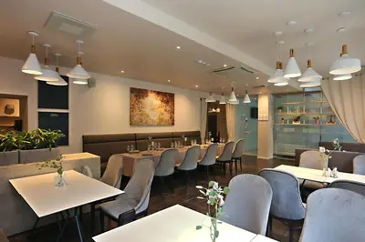 a restaurant with tables and chairs in a room at City Hotels Algirdas in Vilnius
