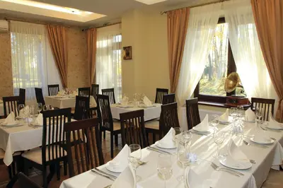 a dining room with tables and chairs with white tablecloths at Grafo Zubovo Hotel & SPA in Bubiai