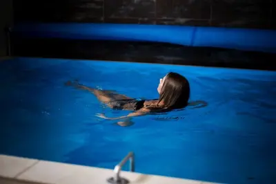 a woman is swimming in a swimming pool at Grafo Zubovo Hotel & SPA in Bubiai