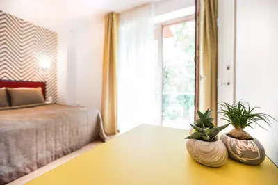 a bedroom with a table with two plants on it at Viešbutis Simpatija in Druskininkai