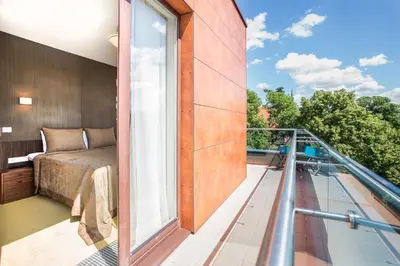 a balcony with a bed and a large window at Viešbutis Simpatija in Druskininkai